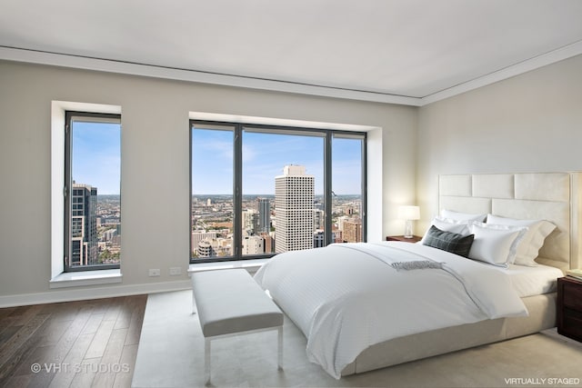 bedroom featuring hardwood / wood-style floors, multiple windows, and crown molding