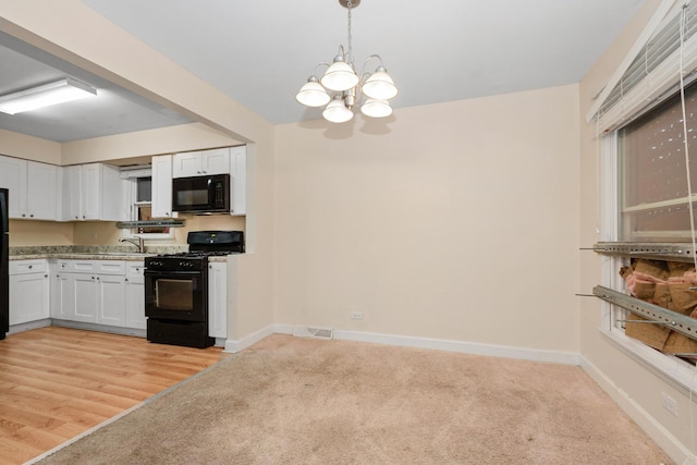 937 E 148th St, Dolton, IL 60419 - kitchen with black appliances, a chandelier, white cabinetry, and light carpet