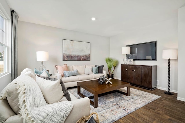 living room with a healthy amount of sunlight and dark hardwood / wood-style flooring