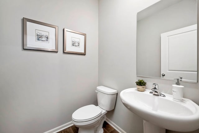 bathroom with hardwood / wood-style flooring, toilet, and sink