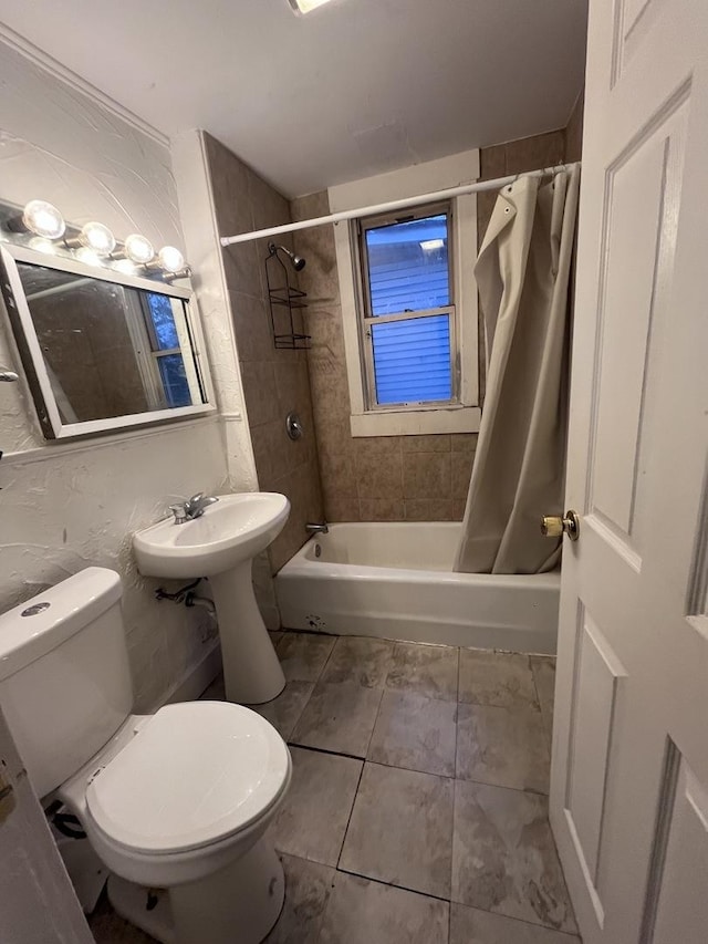 full bathroom with sink, shower / tub combo, and toilet