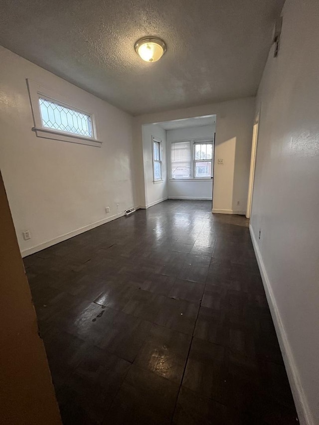 unfurnished room featuring a textured ceiling