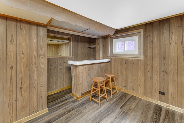 bar with wooden walls and dark wood-type flooring