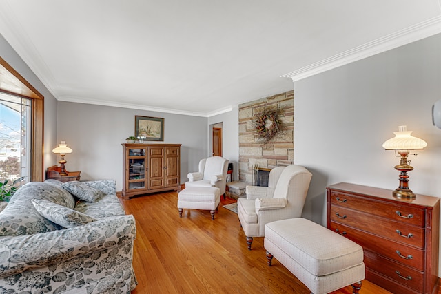 living room featuring a fireplace, light hardwood / wood-style flooring, and crown molding