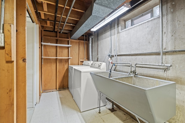 clothes washing area featuring independent washer and dryer and sink