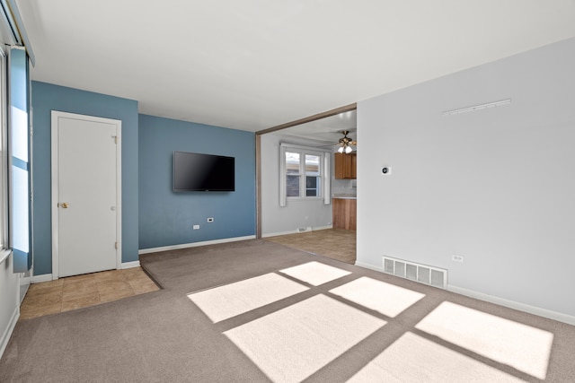 unfurnished living room with ceiling fan and carpet floors