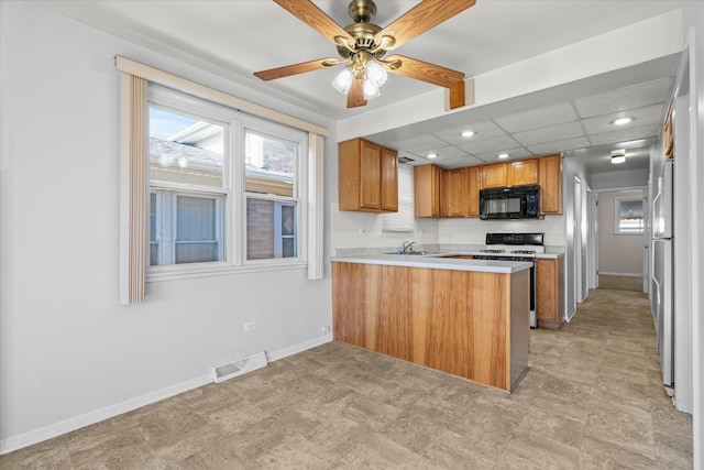 kitchen with kitchen peninsula, a paneled ceiling, ceiling fan, sink, and black appliances