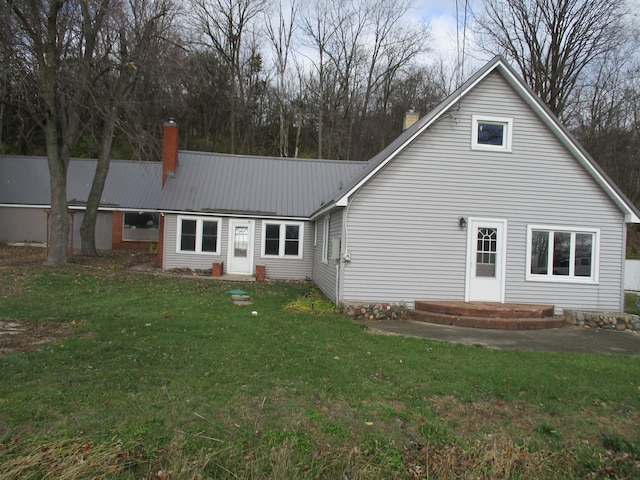 313 E Jackson St, Seneca, IL 61360 - rear view of property with a chimney, a yard, and metal roof