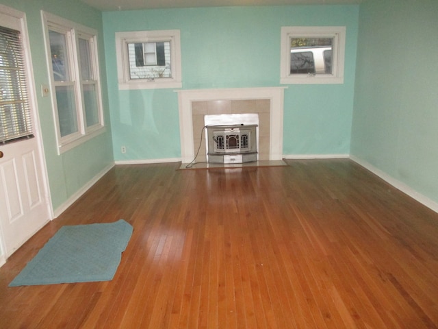 unfurnished living room with a wood stove and dark wood-type flooring