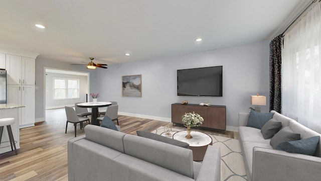 living room with light hardwood / wood-style flooring and ceiling fan