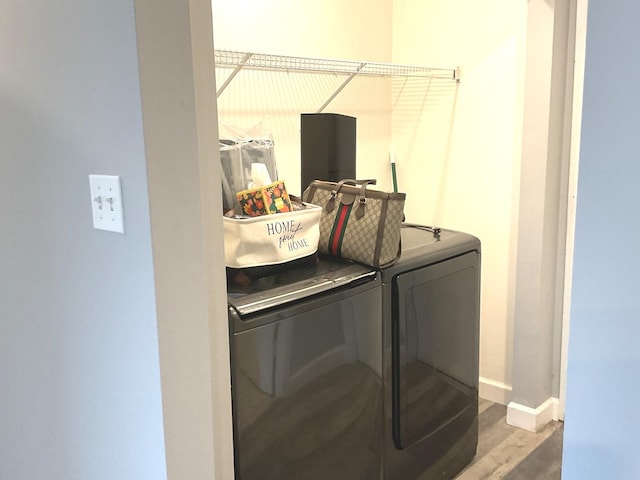 clothes washing area featuring hardwood / wood-style flooring and independent washer and dryer