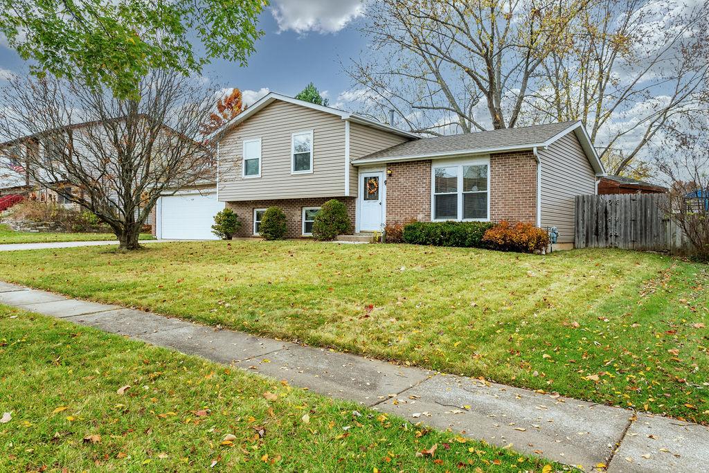 tri-level home with a garage and a front lawn