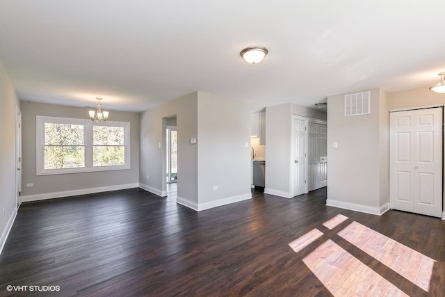 unfurnished living room with dark hardwood / wood-style floors and an inviting chandelier