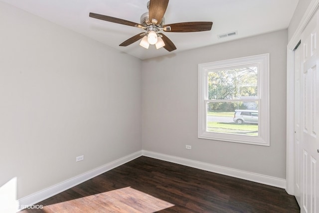 empty room with ceiling fan and dark hardwood / wood-style flooring