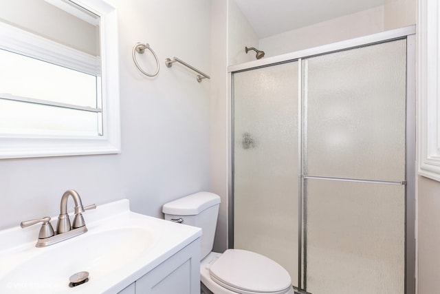 bathroom featuring vanity, toilet, and a shower with door