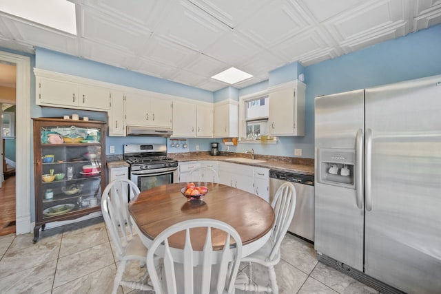 kitchen featuring light tile patterned flooring, appliances with stainless steel finishes, sink, and cream cabinets