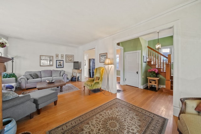 living room featuring ornamental molding, a notable chandelier, and hardwood / wood-style flooring