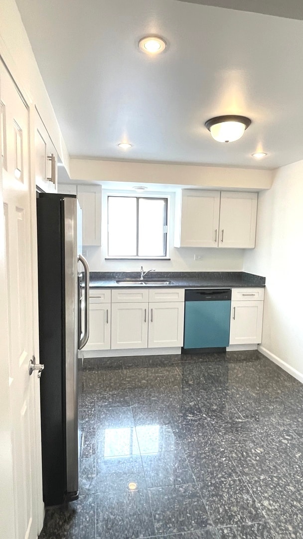 kitchen with white cabinets, white appliances, baseboard heating, and sink