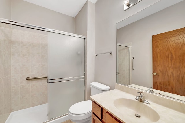 bathroom featuring a shower with door, vanity, and toilet