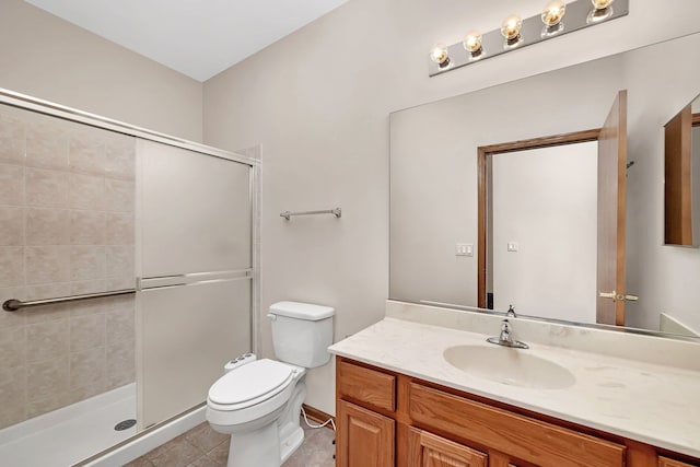 bathroom with tile patterned floors, vanity, toilet, and a shower with shower door