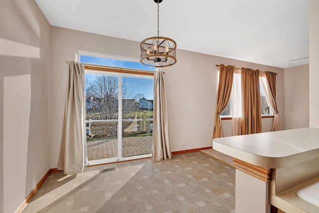 unfurnished dining area with plenty of natural light and an inviting chandelier