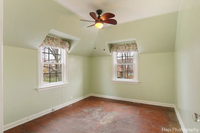 bonus room featuring dark wood-type flooring, vaulted ceiling, and a healthy amount of sunlight