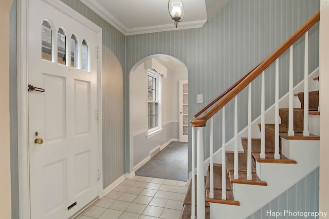 foyer entrance featuring light tile patterned floors and crown molding