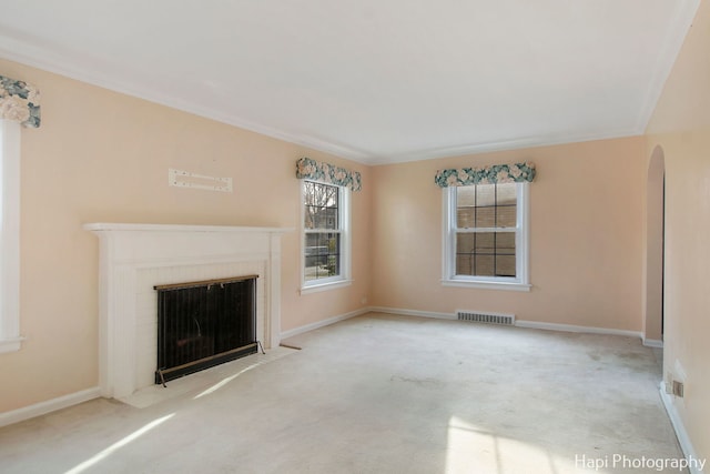 unfurnished living room featuring light colored carpet and crown molding