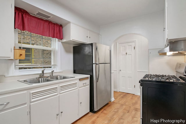 kitchen with white cabinets, sink, light hardwood / wood-style flooring, black range with gas cooktop, and stainless steel refrigerator