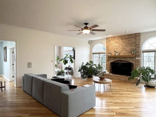 living room with a fireplace, light hardwood / wood-style flooring, plenty of natural light, and ceiling fan