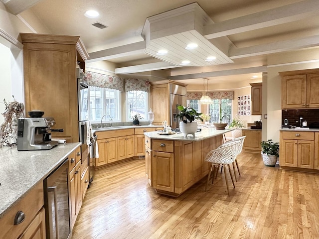 kitchen featuring wine cooler, a center island, hanging light fixtures, and light wood-type flooring