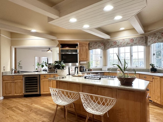 kitchen featuring light hardwood / wood-style flooring, wine cooler, ceiling fan, and a kitchen island