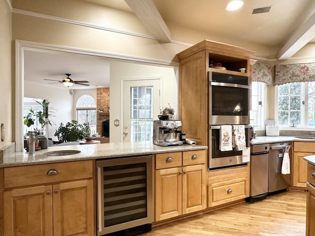 kitchen featuring ceiling fan, sink, beverage cooler, light hardwood / wood-style floors, and appliances with stainless steel finishes