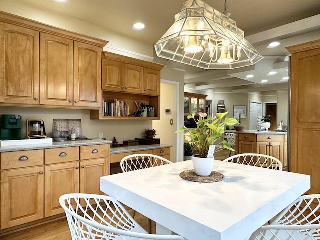 kitchen with beamed ceiling, decorative light fixtures, and light hardwood / wood-style floors