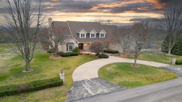 cape cod home with a lawn