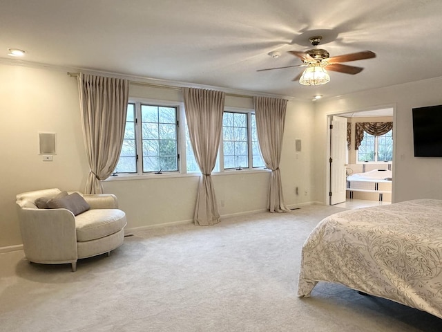 bedroom with ceiling fan, light colored carpet, ensuite bathroom, and crown molding