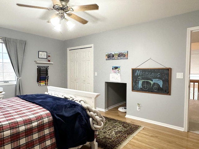 bedroom with ceiling fan, a closet, and hardwood / wood-style flooring