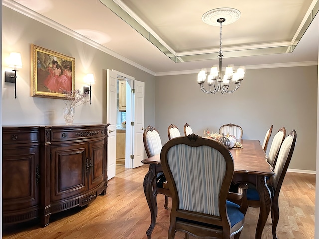 dining area featuring light wood-type flooring, crown molding, and an inviting chandelier