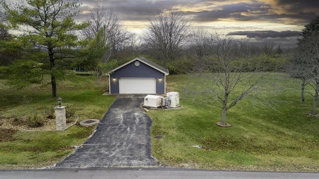 view of front of property featuring a lawn, an outdoor structure, and a garage