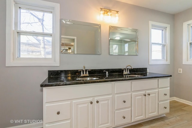 bathroom with hardwood / wood-style floors, vanity, and a healthy amount of sunlight