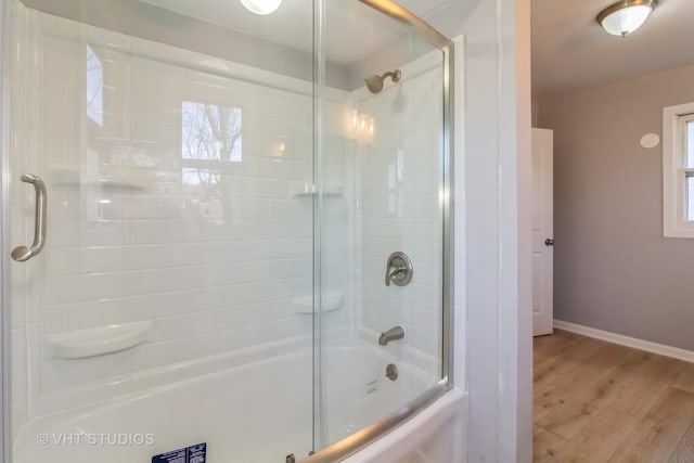 bathroom featuring wood-type flooring and enclosed tub / shower combo