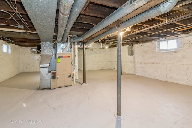 basement featuring electric panel and heating unit