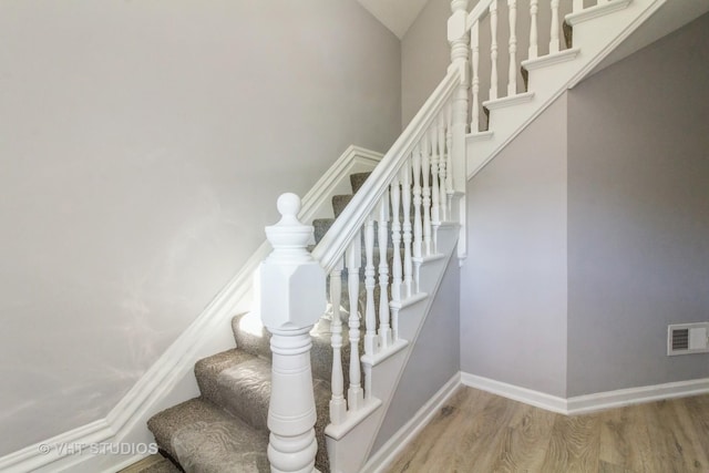 stairway featuring hardwood / wood-style floors and lofted ceiling