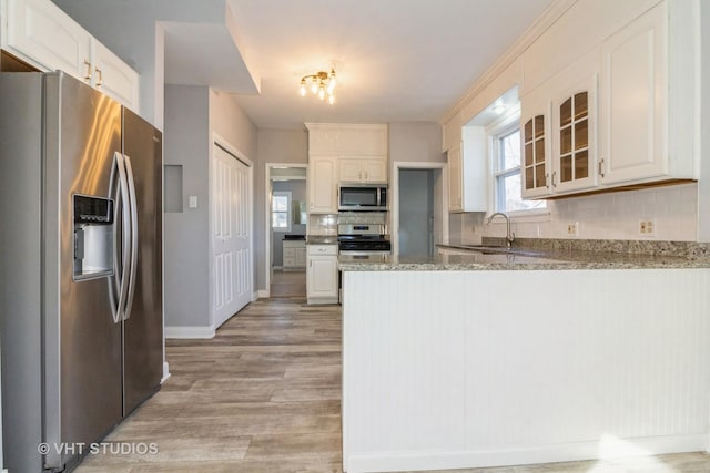 kitchen featuring sink, white cabinets, stainless steel appliances, and light hardwood / wood-style floors