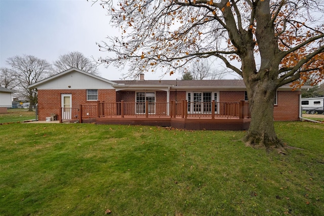 back of property featuring a yard and a wooden deck