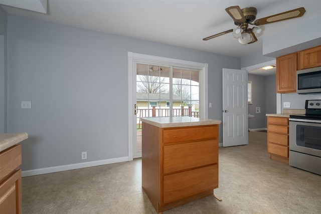 kitchen with ceiling fan, a center island, and stainless steel appliances