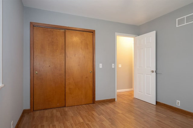 unfurnished bedroom with light hardwood / wood-style floors and a closet