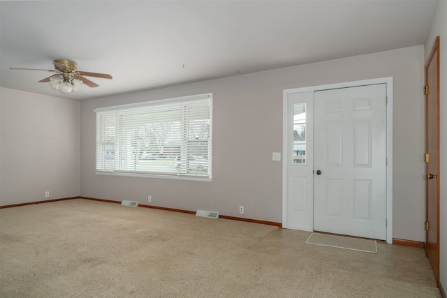 carpeted entrance foyer featuring plenty of natural light and ceiling fan