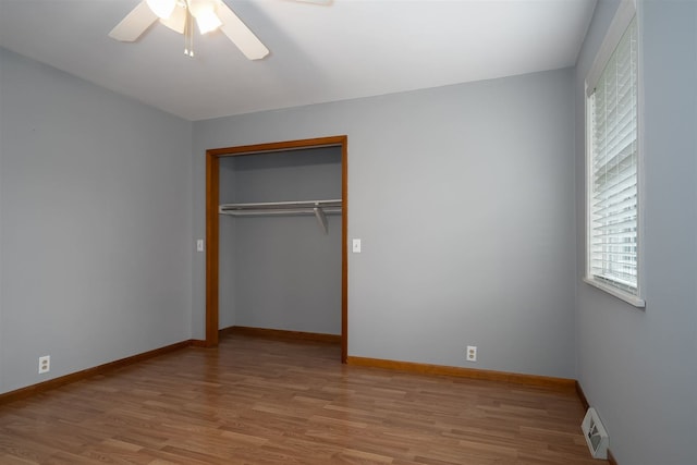 unfurnished bedroom with ceiling fan, light hardwood / wood-style floors, and a closet