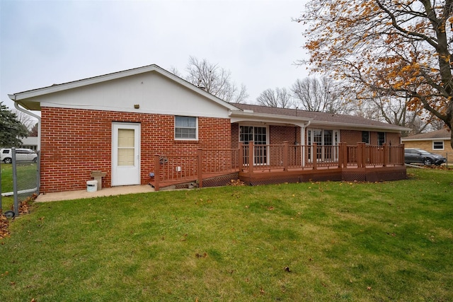 rear view of house featuring a lawn and a wooden deck